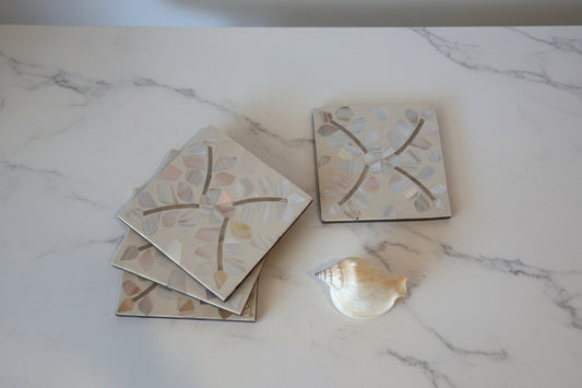 Decorative mother of pearl coasters with flower patterns on a white surface